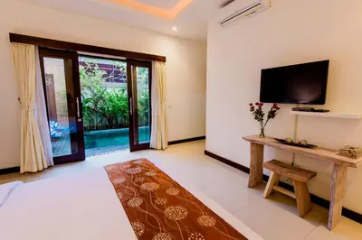 a living room with a flat screen tv and a tv stand at Villa Raka Managed by Manara in Legian