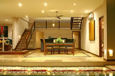 a living room with a table and a staircase at Danoya Private Luxury Residences in Seminyak
