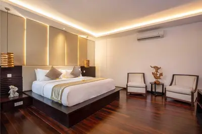 a bedroom with a large bed and two chairs at Danoya Private Luxury Residences in Seminyak