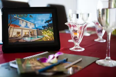 a tablet sitting on a table with wine glasses at Danoya Private Luxury Residences in Seminyak