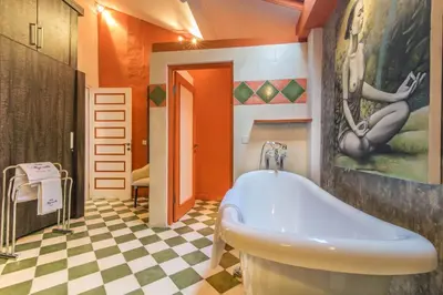 a bathroom with a tub and a painting on the wall at Villa Majorelle Bali in Seminyak