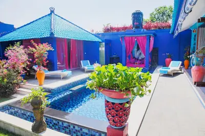 a blue house with a swimming pool and some plants at Villa Majorelle Bali in Seminyak
