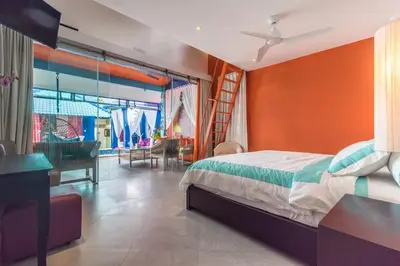 a bedroom with a bed with an orange wall at Villa Majorelle Bali in Seminyak