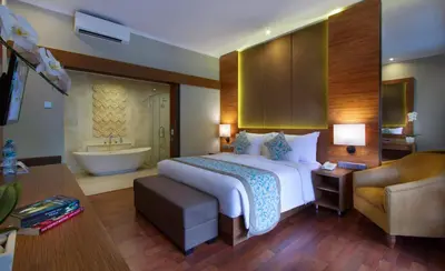 a hotel room with a bed and a bathroom at Adhi Jaya Hotel in Kuta