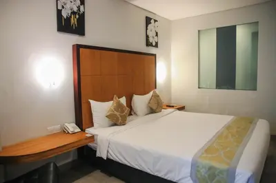 a hotel room with a bed and a telephone at Dekuta in Kuta