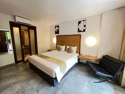 a bedroom with a bed and a chair in it at Dekuta in Kuta