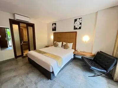 a bedroom with a bed and a chair in it at Dekuta in Kuta