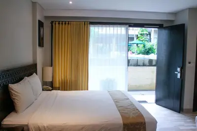 a bedroom with a large bed and a large window at Dekuta in Kuta