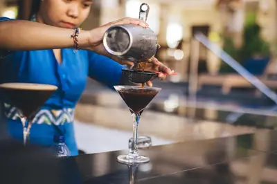 a woman making a cocktail in a martini glass at The Niche Bali in Legian