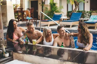 a group of men and women in a swimming pool at The Niche Bali in Legian