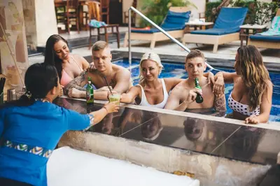 a group of people sitting in a swimming pool at The Niche Bali in Legian