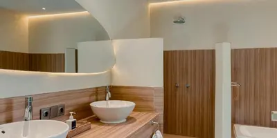 a bathroom with two sinks and a large mirror at Aruni Bali Jimbaran Boutique Villa in Jimbaran