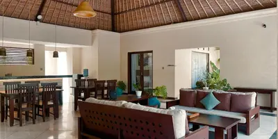 a restaurant with chairs and tables and a bar at Aruni Bali Jimbaran Boutique Villa in Jimbaran
