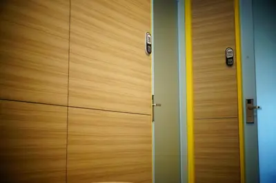 a pair of wooden doors in a room at Borough Capsule Hostel Bali in Legian
