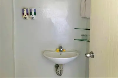 a white sink in a bathroom next to a door at The Yani Hotel Bali in Denpasar
