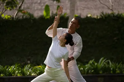 a man and a woman reaching up to catch a frisbee at Kayumanis Jimbaran Private Villas & Spa in Jimbaran