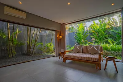 a living room with a couch and a large window at Ziva a Boutique Villa in Seminyak
