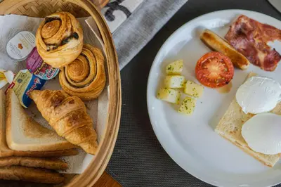 a plate of food with bread and pastries on a table at Ziva a Boutique Villa in Seminyak