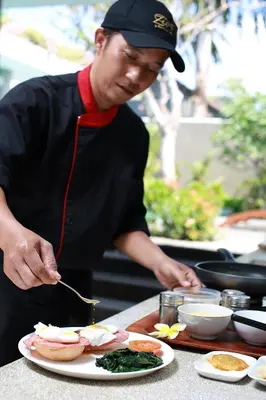 a man preparing food on a table with a plate of food at Ziva a Boutique Villa in Seminyak