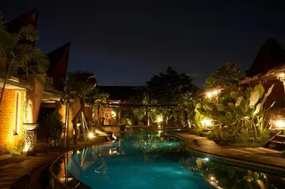 a swimming pool in a yard at night at The Garden Villa in Sanur