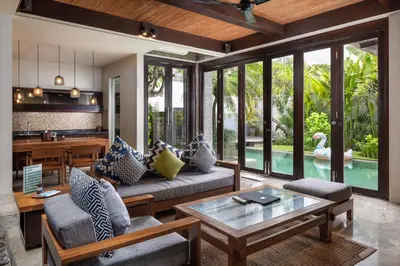 a living room with a couch and a table at Le Jardin Villas Seminyak in Seminyak