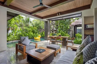 an outdoor patio with a table and chairs at Le Jardin Villas Seminyak in Seminyak