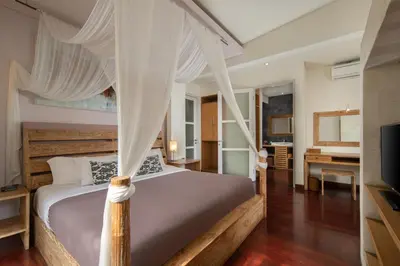 a bedroom with a canopy bed and a desk at The Seiryu Boutique Bali Villas in Seminyak