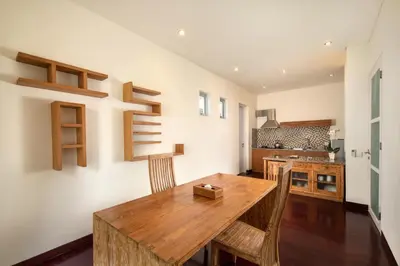 a dining room with a wooden table and chairs at The Seiryu Boutique Bali Villas in Seminyak