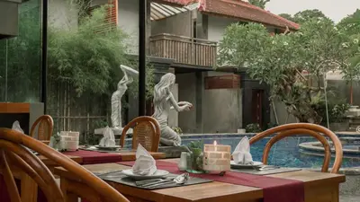 a wooden table with chairs and a table with a table cloth at Annora Villas Seminyak in Seminyak