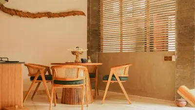 a dining room with a table and chairs and a window at Annora Villas Seminyak in Seminyak