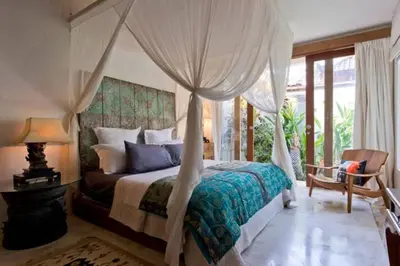a bedroom with a bed with a canopy at Baby Melon Villas in Seminyak