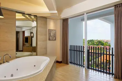 a bathroom with a tub and a large window at Fairfield by Marriott Bali Legian in Legian