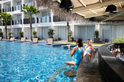 two girls sitting in the pool at a hotel at Fairfield by Marriott Bali Legian in Legian