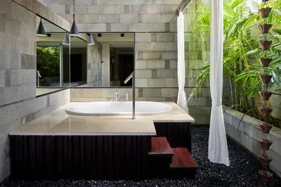 a bathroom with a tub and a mirror at Fairfield by Marriott Bali Legian in Legian