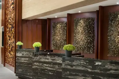 a lobby with a black counter with potted plants at Fairfield by Marriott Bali Legian in Legian