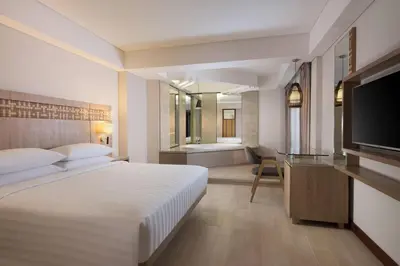 a hotel room with a bed and a television at Fairfield by Marriott Bali Legian in Legian