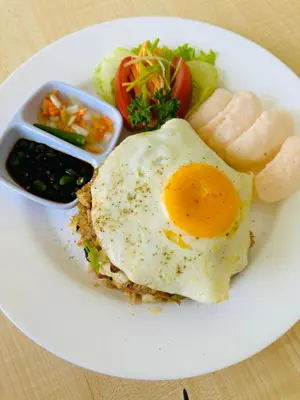 a plate of food with an egg and some vegetables at The Taman Ayu Seminyak 10 Minute walking to the BEACH in Seminyak