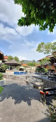 a park with a bench in front of a building at The Taman Ayu Seminyak 10 Minute walking to the BEACH in Seminyak