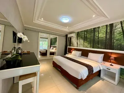 a bedroom with a bed and a desk and a window at The Taman Ayu Seminyak 10 Minute walking to the BEACH in Seminyak