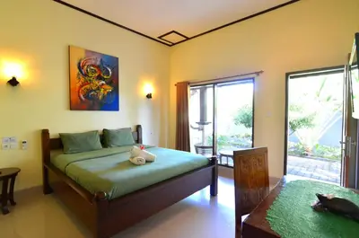 a bedroom with a bed and a large window at Arik Homestay Canggu in Canggu