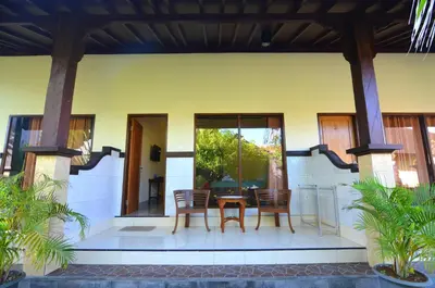 a patio of a house with a table and chairs at Arik Homestay Canggu in Canggu