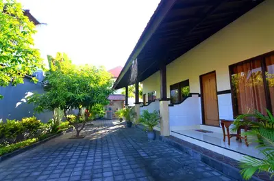 a courtyard of a house with chairs and trees at Arik Homestay Canggu in Canggu