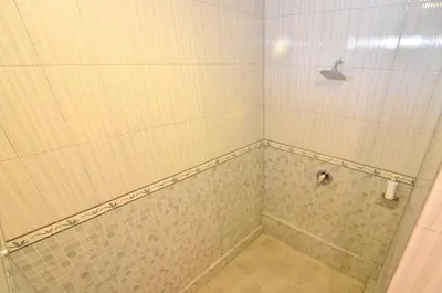 a bathroom with a shower with a tiled floor at Arik Homestay Canggu in Canggu