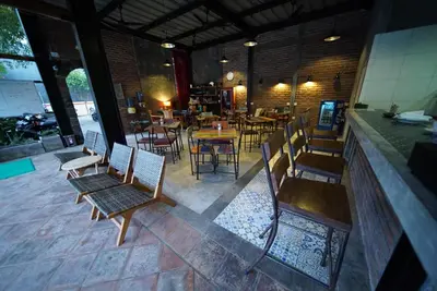 a restaurant with chairs and tables and a bar at Easy Surf Camp in Kuta