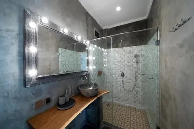 a bathroom with a sink and a shower with a mirror at Easy Surf Camp in Kuta