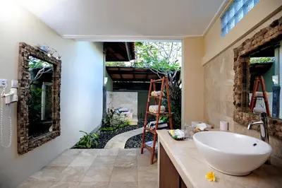a bathroom with a sink and a large mirror at Bali Aroma Exclusive Villas in Seminyak