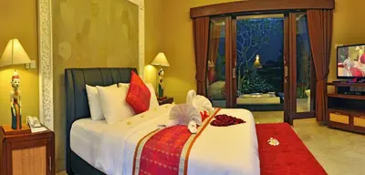 a baby is laying on a bed in a bedroom at Bali Aroma Exclusive Villas in Seminyak