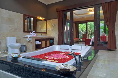 a bathroom with a large tub filled with red flowers at Bali Aroma Exclusive Villas in Seminyak