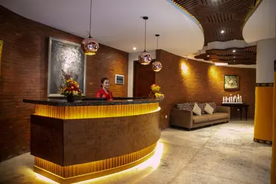 a man standing behind a bar in a lobby at djabu Seminyak Hotel in Seminyak