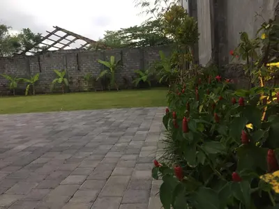 a brick patio with flowers and a fence at Dikubu Belong Seminyak in Seminyak